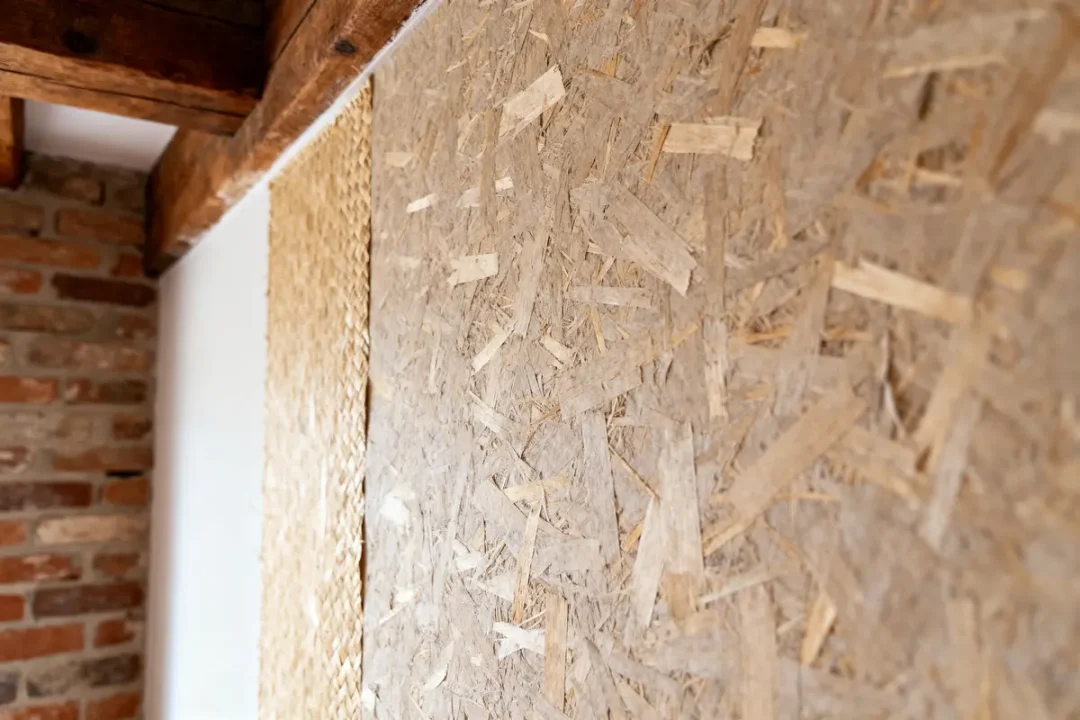 Mur intérieur en bois, briques apparentes et matériaux naturels. Ambiance rustique et chaleureuse.