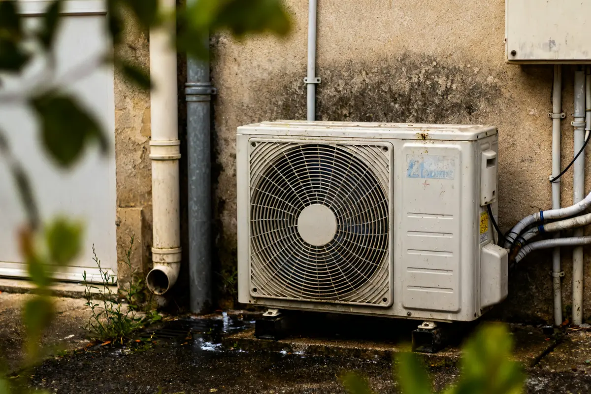 Unité extérieure de climatisation nécessitant nettoyage groupe extérieure clim près d'un mur délabré